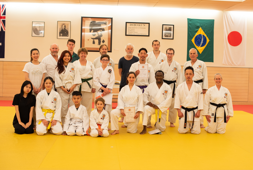 A large group of karate students pose for the camera.